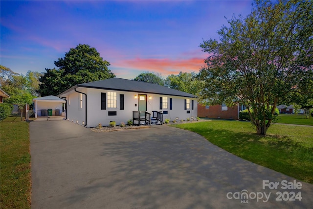 ranch-style home featuring a yard and a carport