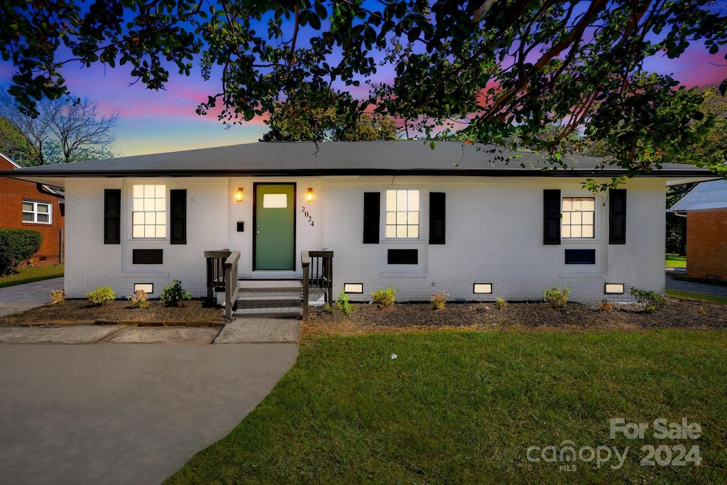 single story home featuring a lawn