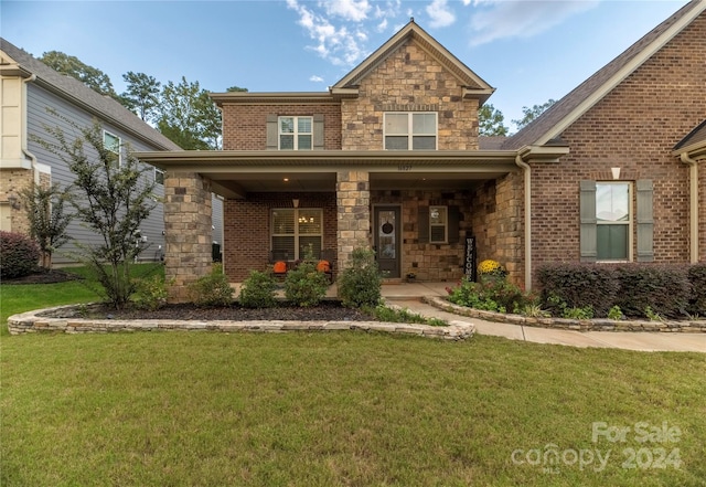 view of front of property with a porch and a front lawn