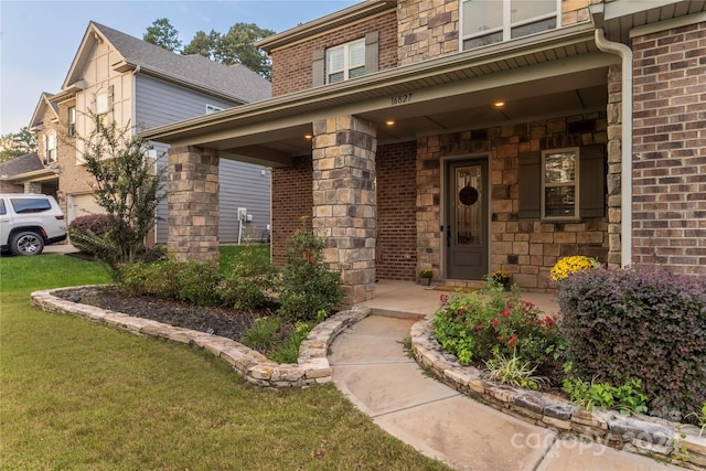 entrance to property with a lawn and a porch