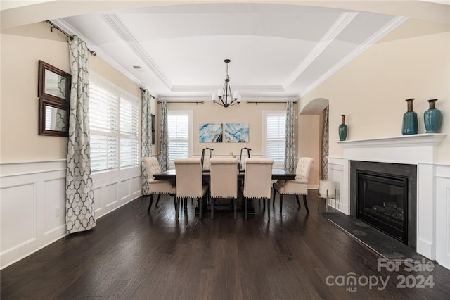 dining area with a raised ceiling, crown molding, and dark wood-type flooring