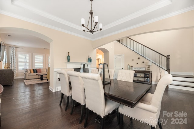 dining area with ornamental molding, a tray ceiling, and dark hardwood / wood-style flooring