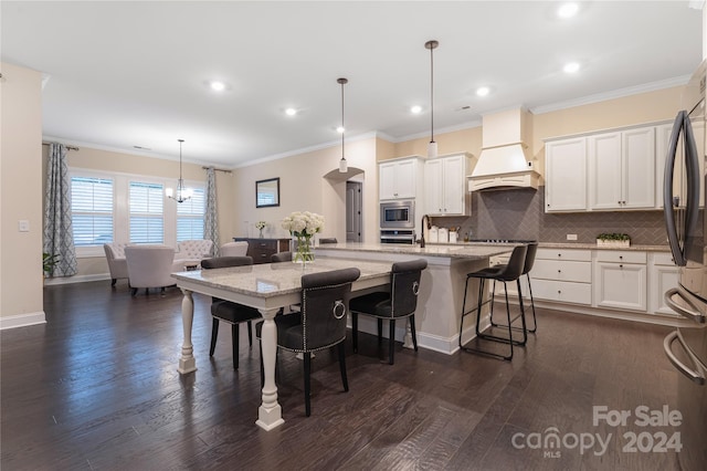 kitchen featuring custom range hood, hanging light fixtures, white cabinetry, dark hardwood / wood-style flooring, and a large island