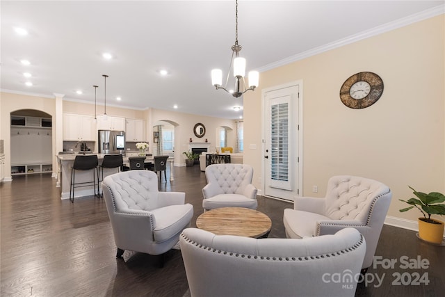 living room featuring ornamental molding, dark wood-type flooring, and a notable chandelier