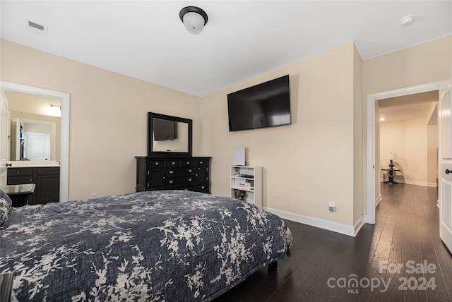 bedroom with connected bathroom and dark hardwood / wood-style floors