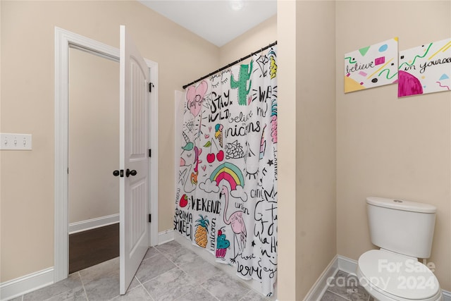 bathroom featuring a shower with shower curtain and toilet