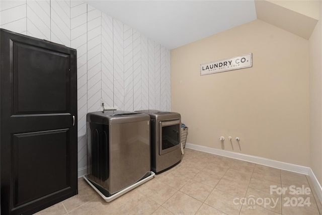 laundry room featuring tile walls, independent washer and dryer, and light tile patterned flooring