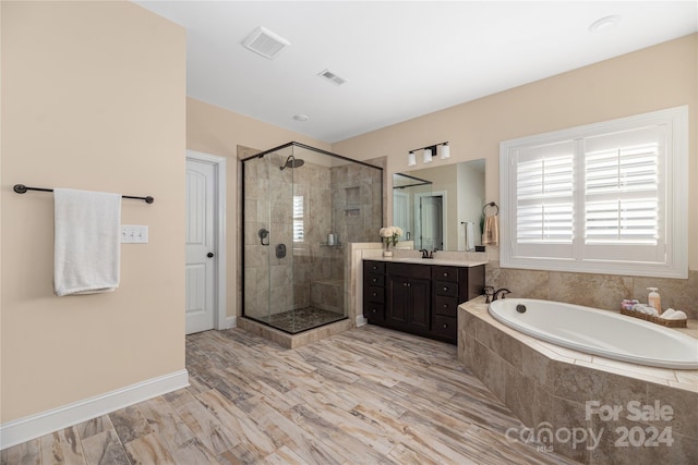 bathroom featuring independent shower and bath and vanity