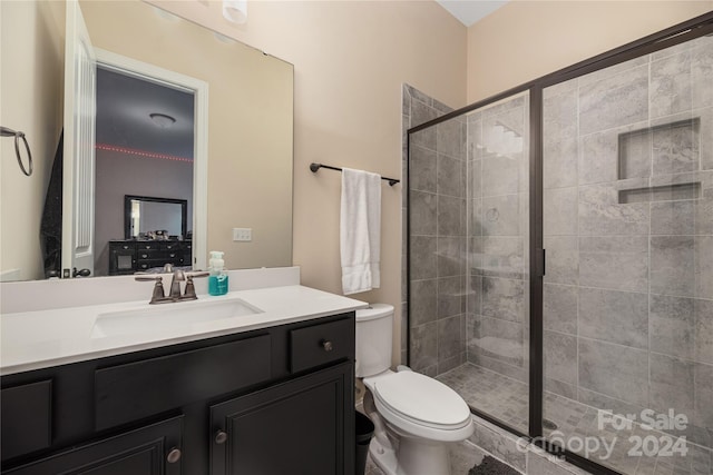 bathroom featuring vanity, toilet, and an enclosed shower