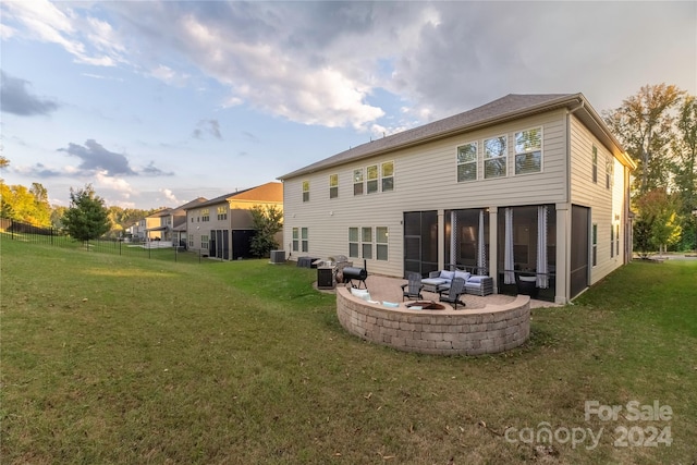 rear view of house featuring cooling unit, a lawn, and a patio