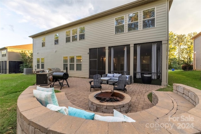 back of property featuring a yard, central air condition unit, an outdoor fire pit, and a patio area