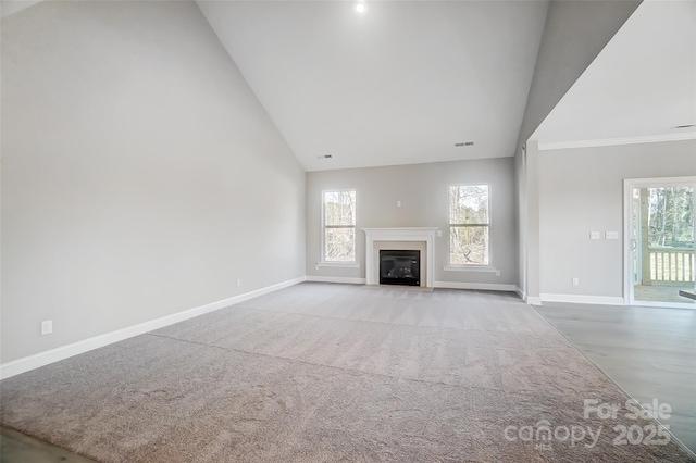 unfurnished living room with high vaulted ceiling and a wealth of natural light