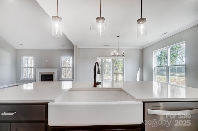 kitchen with pendant lighting, sink, stainless steel dishwasher, and an inviting chandelier