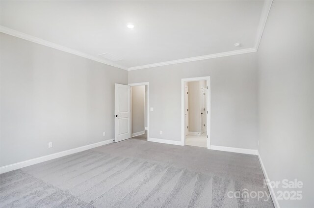 empty room featuring light colored carpet and crown molding