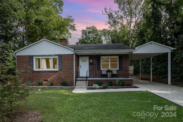 view of front facade with a lawn, a carport, and covered porch