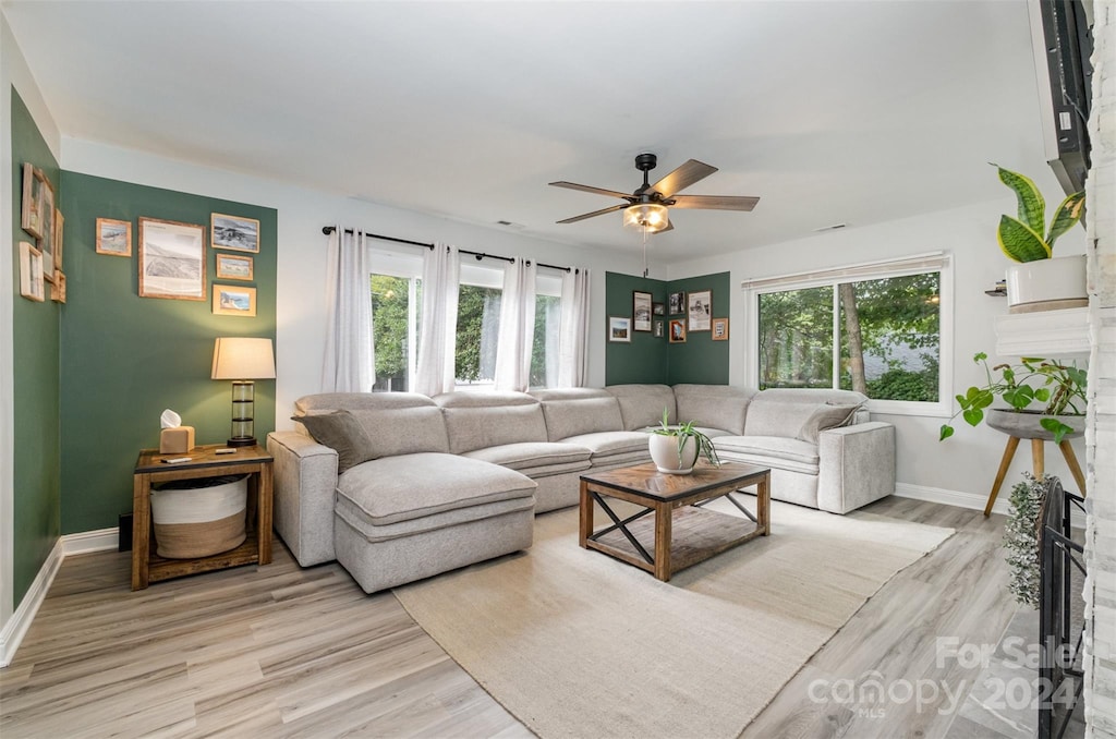 living room featuring a healthy amount of sunlight, a fireplace, and light hardwood / wood-style flooring