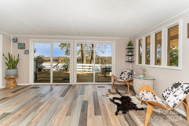 living area featuring ornamental molding, a textured ceiling, and hardwood / wood-style floors