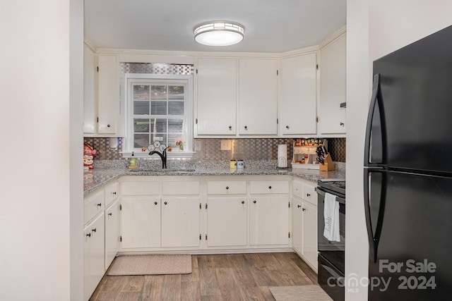 kitchen featuring black appliances, decorative backsplash, light stone counters, and light hardwood / wood-style floors