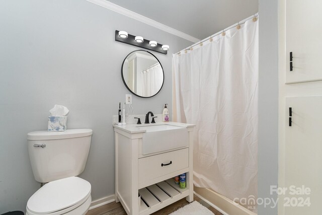 bathroom featuring hardwood / wood-style flooring, toilet, ornamental molding, vanity, and a shower with curtain