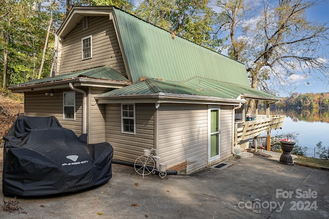 rear view of property with a water view and a patio