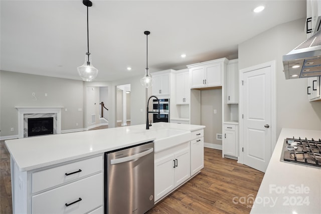 kitchen featuring white cabinetry, a kitchen island with sink, stainless steel appliances, and decorative light fixtures