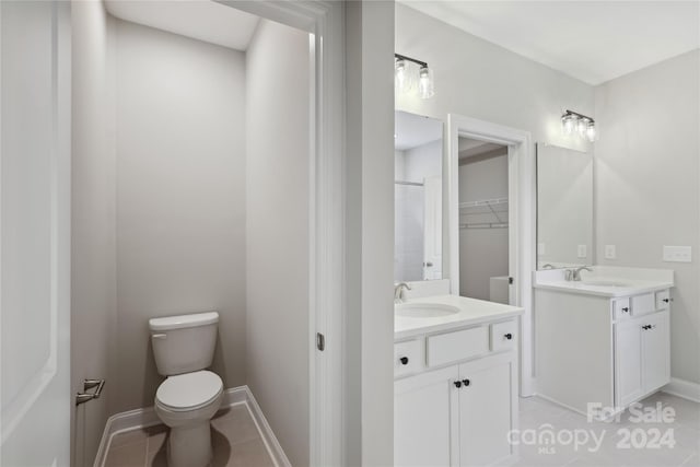 bathroom featuring toilet, vanity, and tile patterned floors