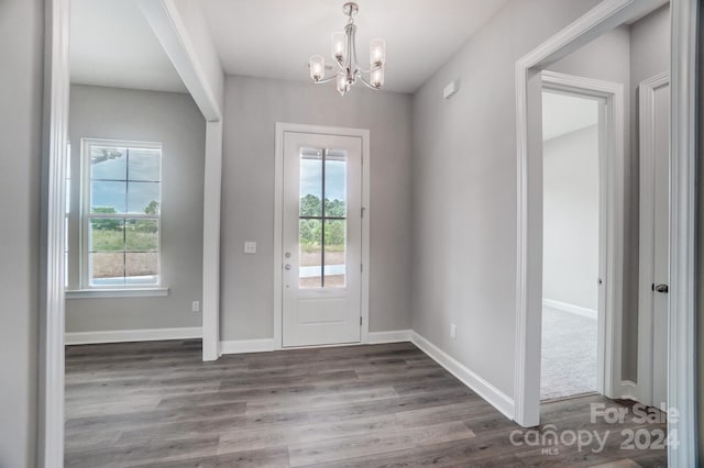 doorway featuring a notable chandelier, dark hardwood / wood-style floors, and a healthy amount of sunlight