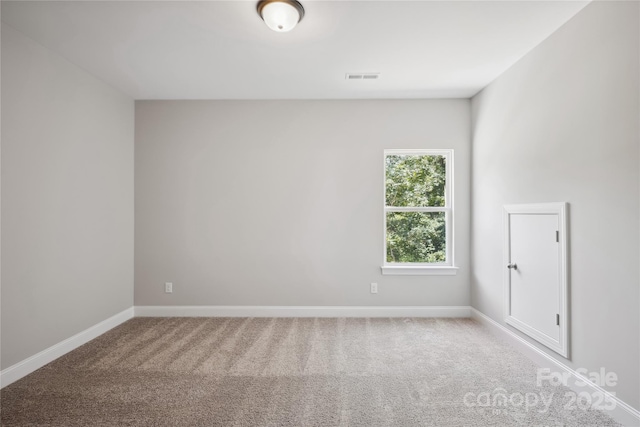 carpeted empty room with visible vents and baseboards