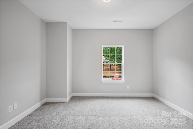 carpeted empty room featuring visible vents and baseboards