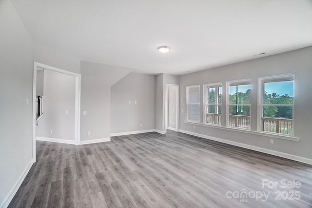 unfurnished room with baseboards and wood finished floors