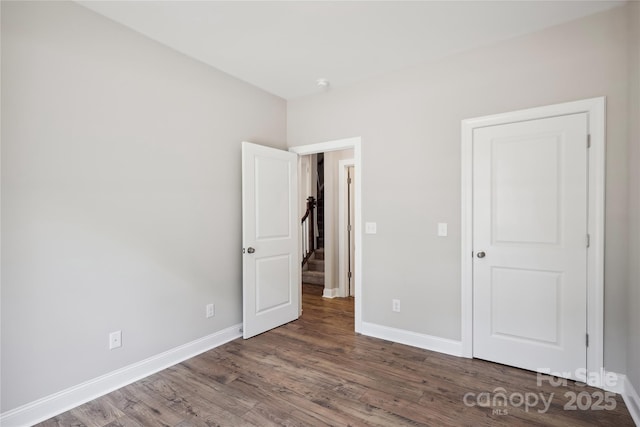 unfurnished bedroom with wood finished floors and baseboards