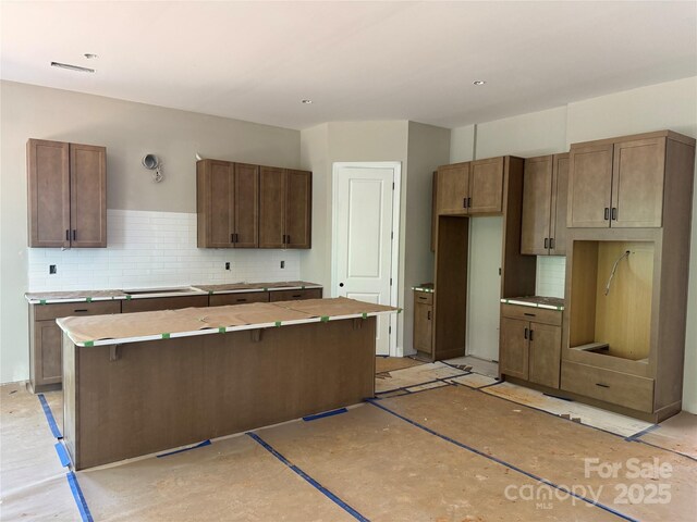552 Fern Hill Rd Unit 21, Mooresville, NC 28117 - kitchen with a kitchen island, backsplash, and light countertops