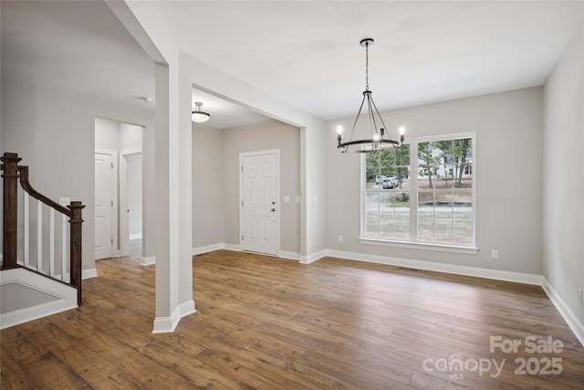 552 Fern Hill Rd Unit 21, Mooresville, NC 28117 - unfurnished dining area featuring a chandelier, wood finished floors, baseboards, and stairs