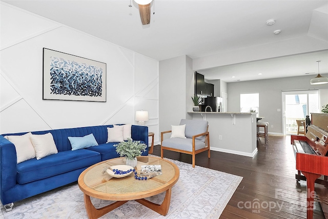 living room featuring ceiling fan and dark hardwood / wood-style flooring