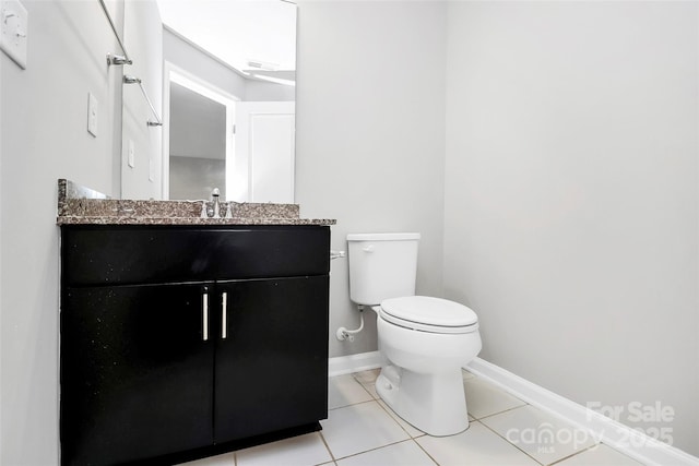 bathroom with toilet, tile patterned floors, and vanity