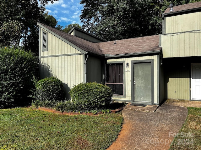 doorway to property featuring a lawn