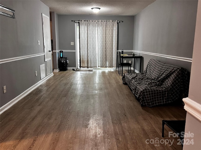 sitting room with a textured ceiling and dark wood-type flooring