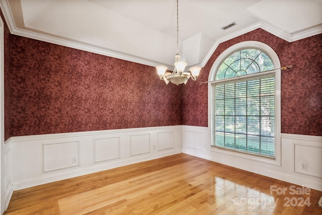 unfurnished room with visible vents, wainscoting, light wood-style floors, wallpapered walls, and a chandelier