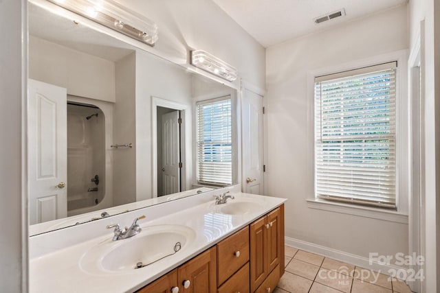 bathroom with visible vents, a sink, tile patterned floors, and double vanity