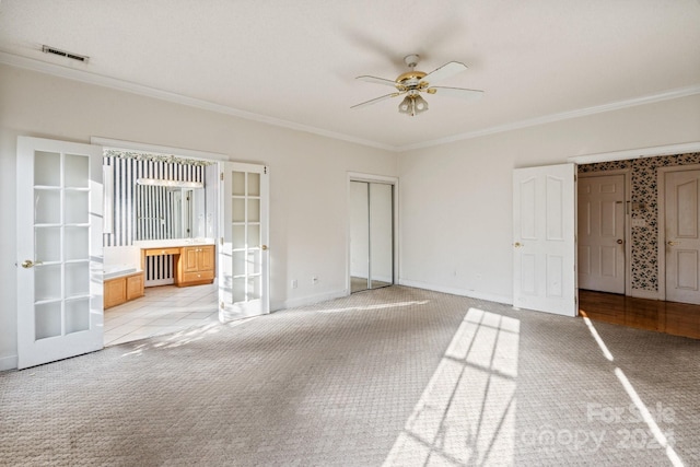 unfurnished bedroom featuring light carpet, ornamental molding, and french doors