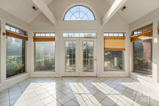 unfurnished sunroom featuring tile patterned flooring, visible vents, and high vaulted ceiling