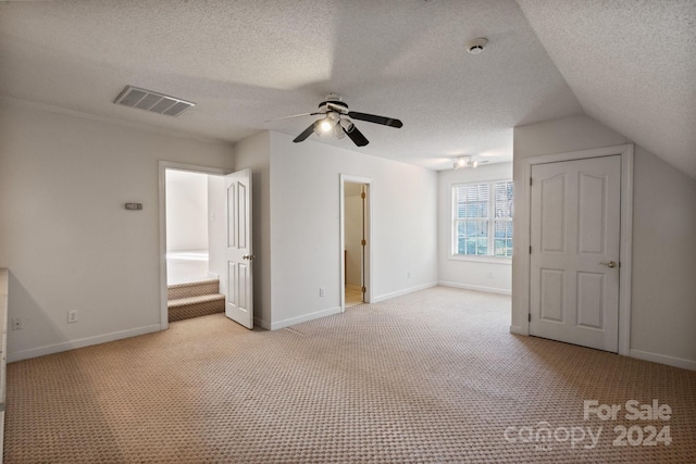 unfurnished bedroom with visible vents, a textured ceiling, baseboards, and light carpet