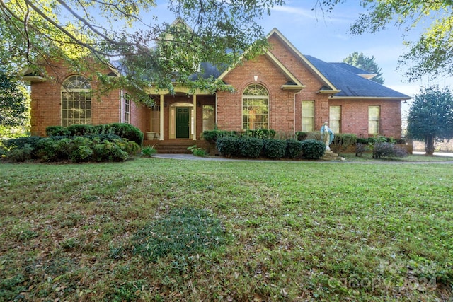 view of front facade featuring a front yard and brick siding