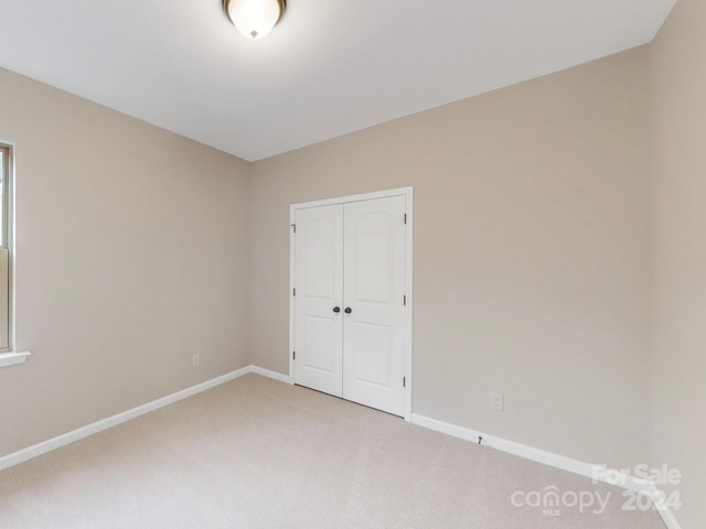 unfurnished bedroom featuring carpet flooring and a closet