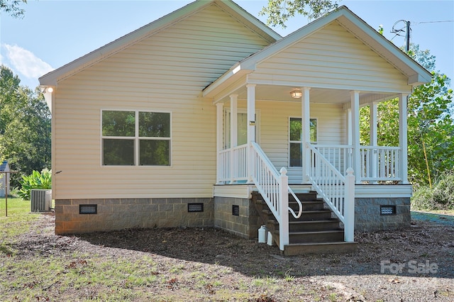 view of front facade with covered porch and central AC