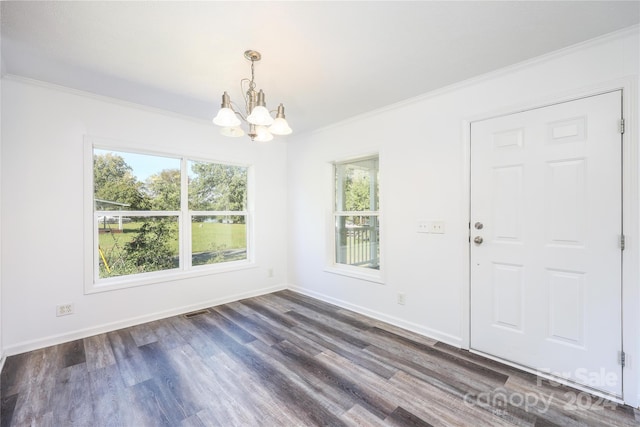 interior space featuring an inviting chandelier, ornamental molding, and dark wood-type flooring