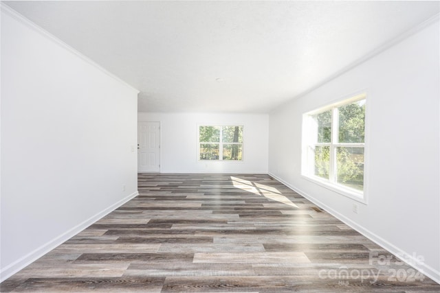 unfurnished room featuring dark hardwood / wood-style floors, a healthy amount of sunlight, and crown molding