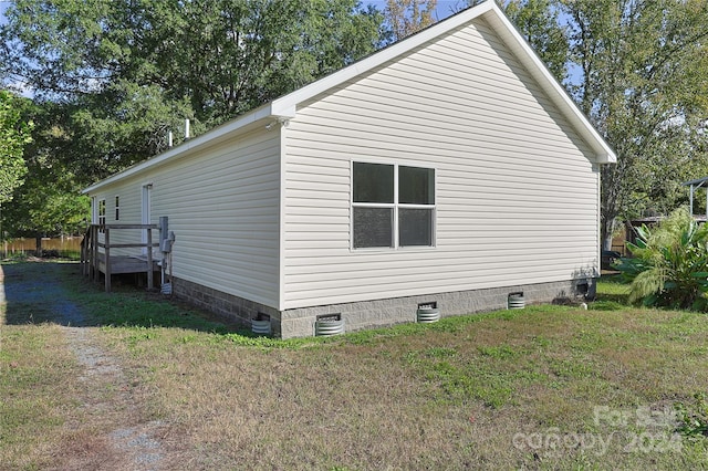 view of home's exterior with a deck and a yard