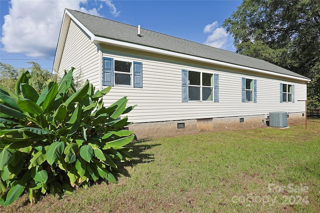 view of home's exterior featuring a lawn and central AC