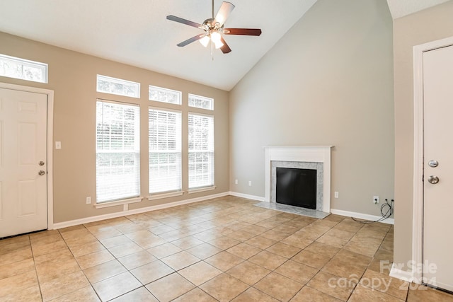 unfurnished living room featuring high vaulted ceiling, ceiling fan, a high end fireplace, and light tile patterned floors